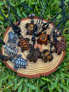 a group of different necklaces sitting on top of a wooden board in the grass