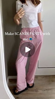 a woman taking a selfie with her cell phone wearing pink and white striped pants