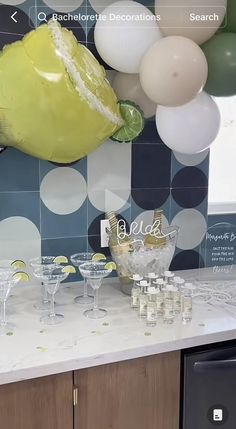 there are many glasses on the counter with balloons in the background