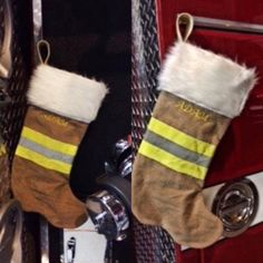 two christmas stockings hanging from the side of a fire truck door, one with white and yellow stripes