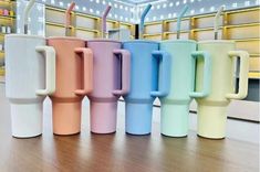 several different colored cups with straws in them