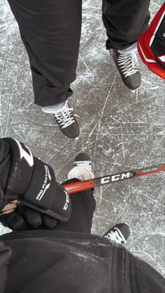 two people standing next to each other on top of an ice covered ground with skis