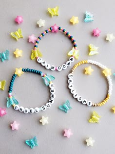 three bracelets with name charms on them and stars scattered around the beaded bracelets