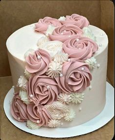 a white and pink cake with flowers on it