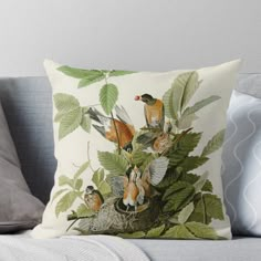 a group of birds sitting on top of a tree branch throw pillow with green leaves