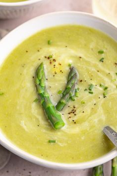 asparagus soup in a white bowl with a spoon