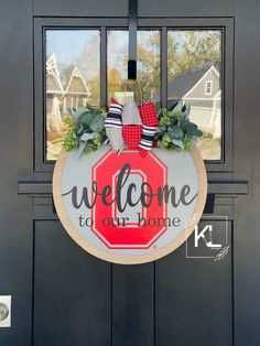 a welcome to our home sign hanging on the front door