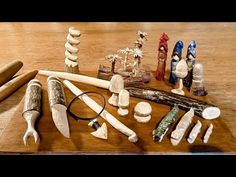 several different types of carved objects on a wooden table with scissors and other items in the foreground