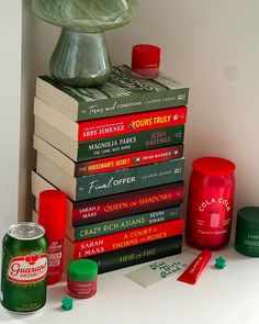 a stack of books sitting on top of a table next to a can of soda