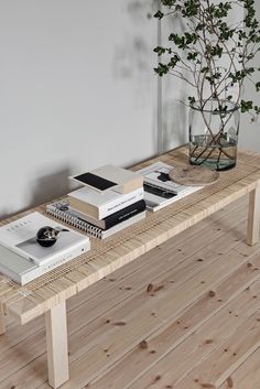 a wooden table topped with books and a vase