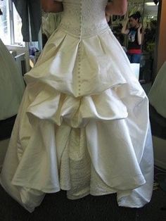 a woman in a white wedding dress is taking a selfie with her cell phone