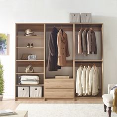 an open closet with clothes and shoes hanging on the wall, next to a white chair