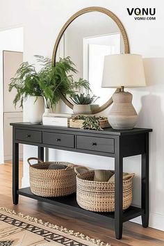 a black console table with two baskets on it and a round mirror in the background