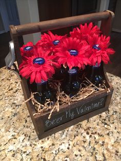 a wooden crate filled with red flowers sitting on top of a counter