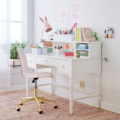 a white desk with a chair and some books on it in a room next to a window