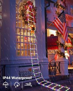 a ladder decorated with christmas lights on the side of a building in front of an american flag