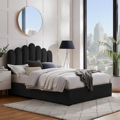 a bedroom with a large window and a view of the city from it's bed