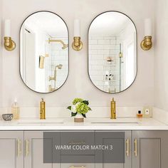 two round mirrors are on the wall above a double vanity with gold faucets