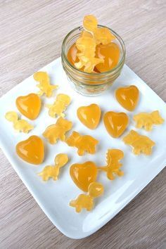 jelly hearts are sitting on a plate next to a glass jar