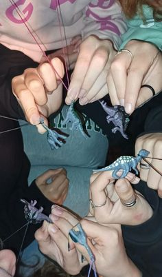 several people are doing different things together with scissors and string to make them look like lizards