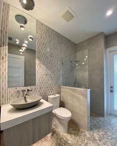 a bathroom with a sink, toilet and mirror in it's centerpieces