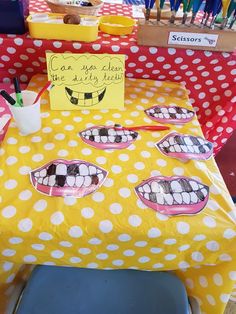 a yellow table topped with lots of paper plates covered in polka dots and toothbrushes