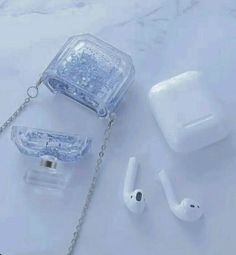 an apple airpods, headphones and chain on a marble surface