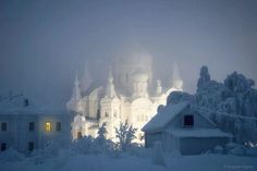 an image of a church that is in the snow with lights shining on it's windows