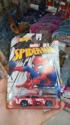 a hand holding a toy car with spiderman on it's front and sides