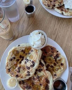 pancakes with bananas and other toppings on a white plate