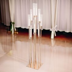 four tall candles stand in the middle of a dance floor