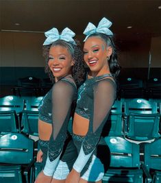 two cheerleaders are posing for the camera