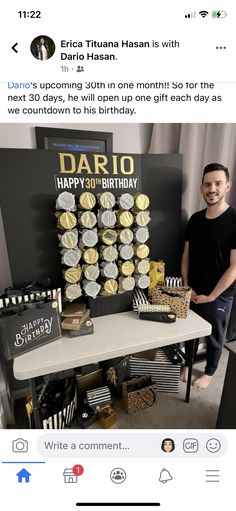 a man standing next to a table with cupcakes on it