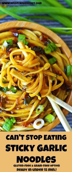 a wooden bowl filled with noodles and vegetables on top of a blue table cloth next to chopsticks