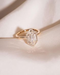 an engagement ring on top of a white cloth