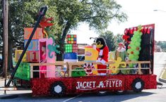 the float is decorated with balloons, gifts and other things to be seen in this parade