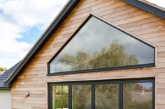 a wooden house with large windows on the side