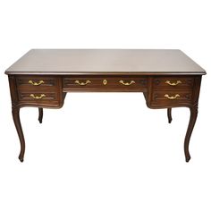 an antique desk with two drawers and gold handles