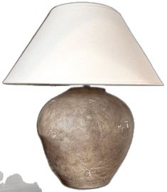 a table lamp with a white shade on it's base next to a wall