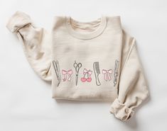 This coquette style, bows and hair tools sweatshirt would make the perfect graduation or appreciation gift for hairstylists! Want this in a t-shirt instead? You can find it here: https://www.etsy.com/listing/1722037453 * HOW TO ORDER * 1. Look through the photos at the different colors and the sizing chart (all shirts & sweatshirts are unisex sizing) 2. Select the size and color you want from the drop down menus. 3. Choose the quantity you want in that size and color. 4. If applicable, add your Cosmetology School Graduation, Cosmetology School Outfits, Hairstylist Gifts, Coquette Hair, Hair Stylist Shirts, Hair Stylist Gifts, Cosmetology School, Coquette Style, Comfort Colors Sweatshirt