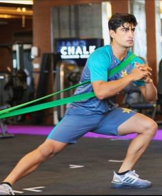 a man holding a green ribbon while standing in a gym