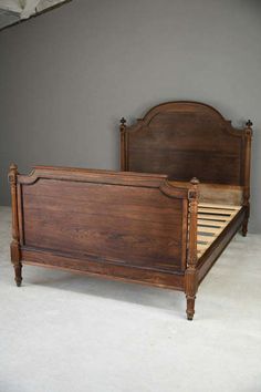 a wooden bed frame with no headboard and foot board is shown in an empty room