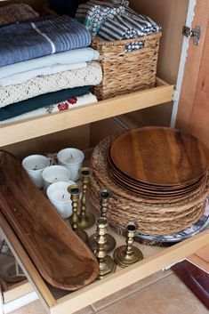 an open cabinet filled with dishes and candles