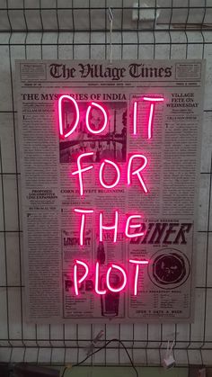 a pink neon sign that says do it for the plot in front of a newspaper