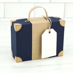 a brown and blue gift bag with two tags attached to the front, sitting on a white surface