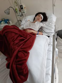 a woman laying in a hospital bed with an oxygen tube attached to the side of her head