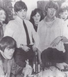 an old black and white photo of some people at a table with wine bottles in front of them