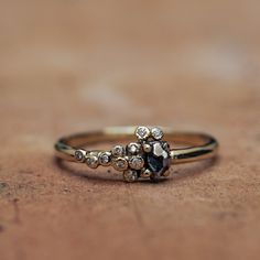 a close up of a gold ring on a wooden surface with small stones in the middle