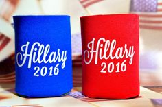 two red and blue can coolers sitting on top of a table next to each other