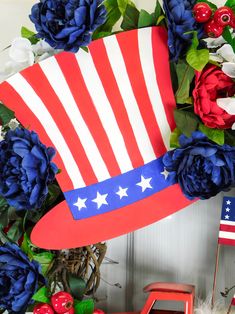 an american flag hat on top of a wreath with red, white and blue flowers